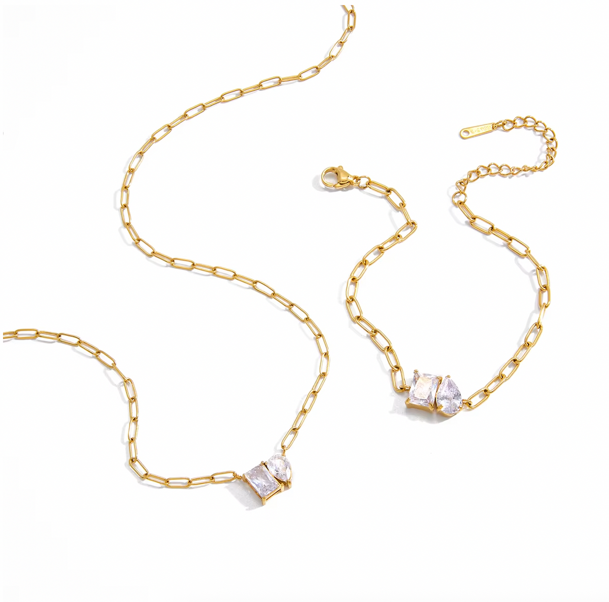 Sharp Halo BRACELET, a gold paperclip chain with a rectangular and teardrop crystal centerpiece, paired with the matching necklace on white.
