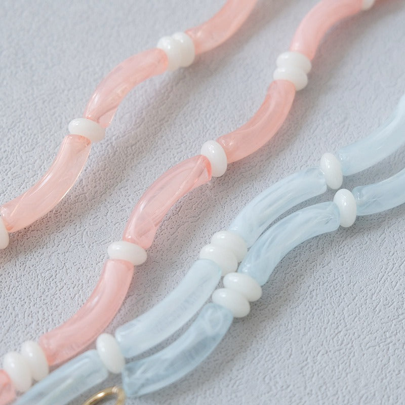 Close-up of pink and blue Smooth Moves PHONE CHAIN tube beads with white spacer beads.