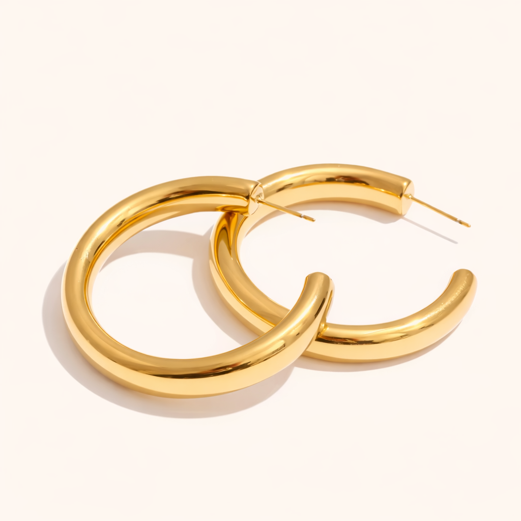 Chunky gold Statement Hoop earrings with a thick rounded tube design, shown as a pair from an angled view.