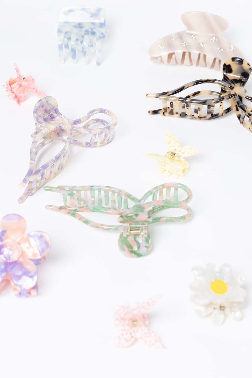 Summer Bliss HAIR CLIP shown among a closer flat-lay assortment of differently shaped acetate hair clips in various colors and patterns.