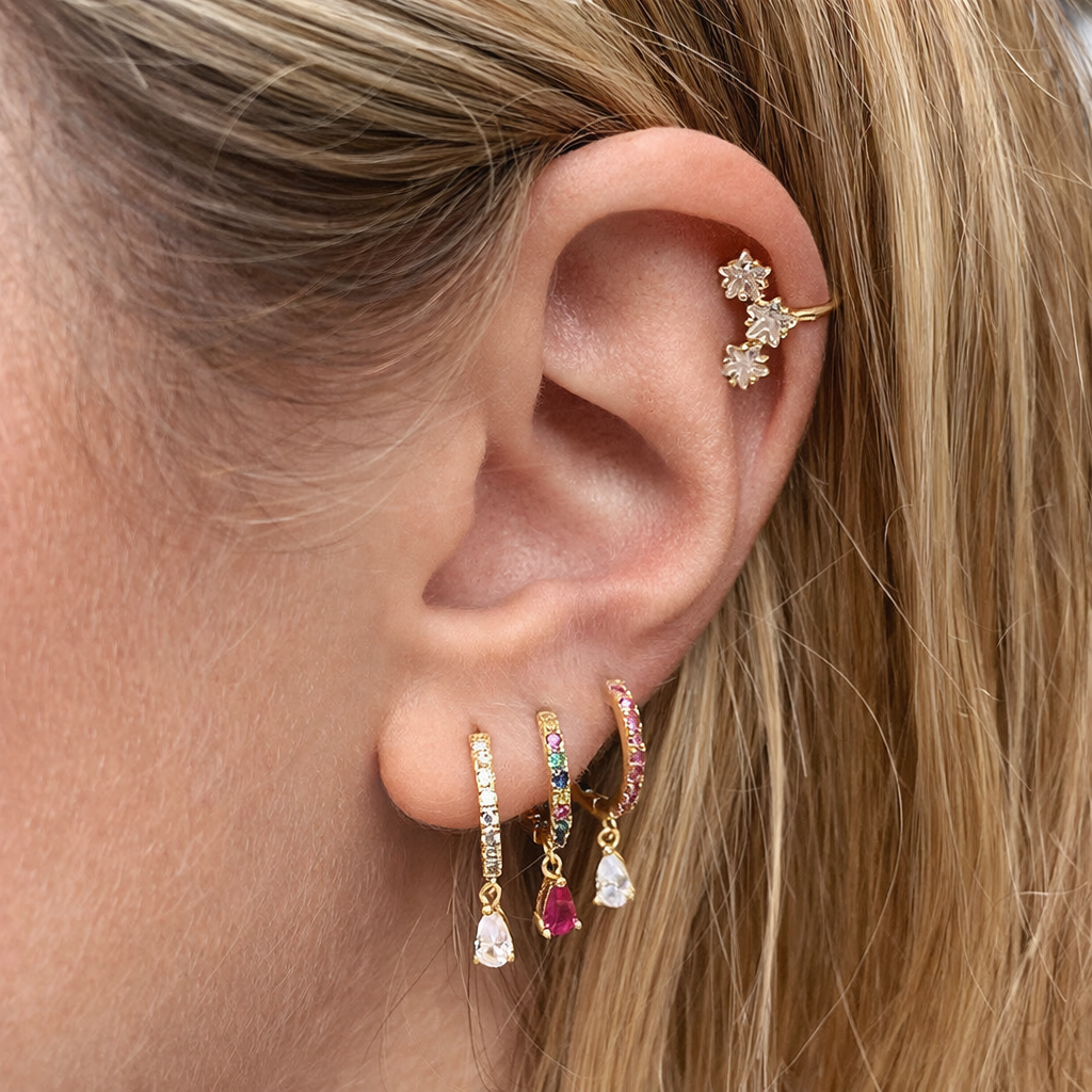 Teardrop Earrings worn stacked with a floral cartilage cuff, three pear-drop hoops layered along the lobe.