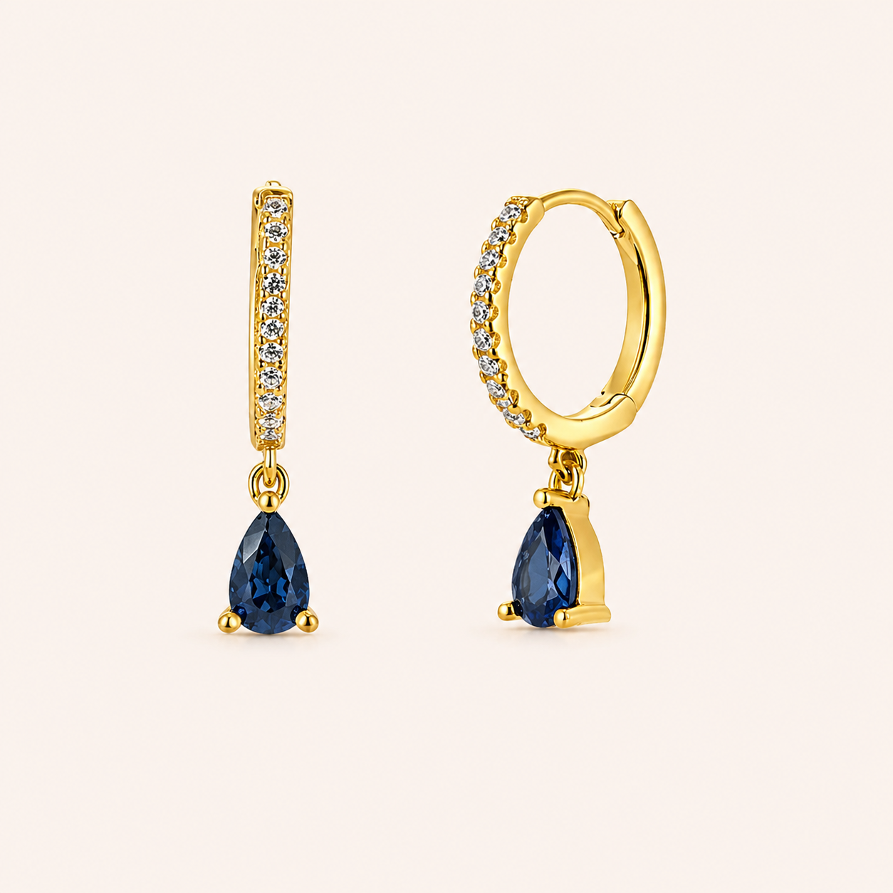 Teardrop Earrings in gold with sapphire-blue crystals, showing the pave hoop and pear-cut crystal drop design.