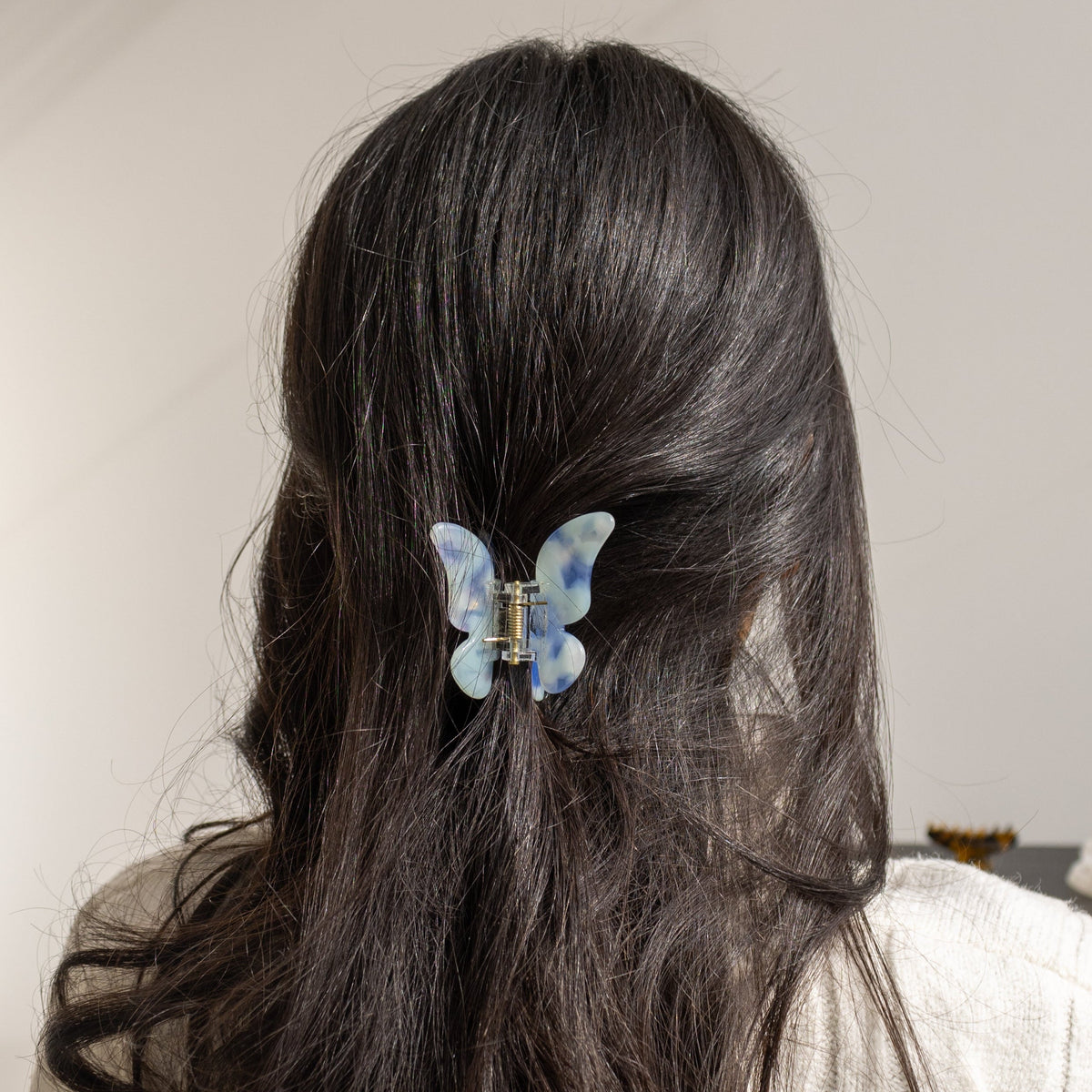 True Paradise HAIR CLIP's blue and white butterfly clip worn in half-up dark hair.