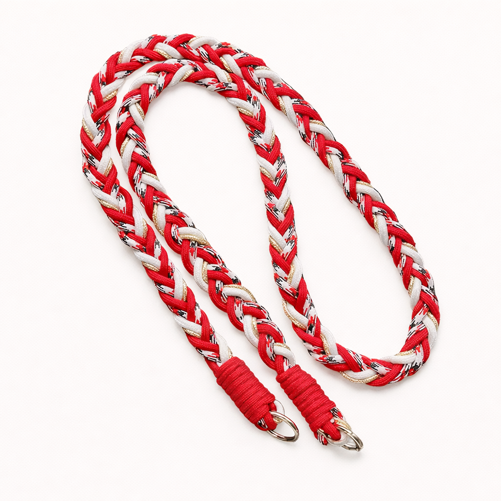 Red, white, and black braided Voyage long phone cord with gold thread, coiled flat with silver rings.