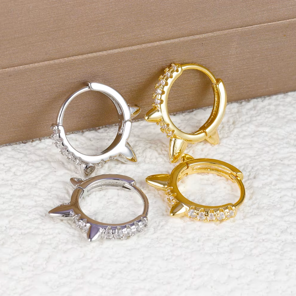 Wild Earrings pave spike huggie hoops in gold and silver tone, two matching pairs shown together closely.