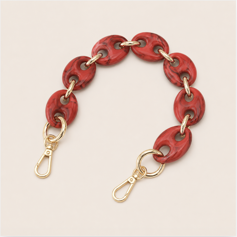 Folie à Trois Wilder short phone chain in red marbled puffed links with gold connectors, laid flat on a cream background.