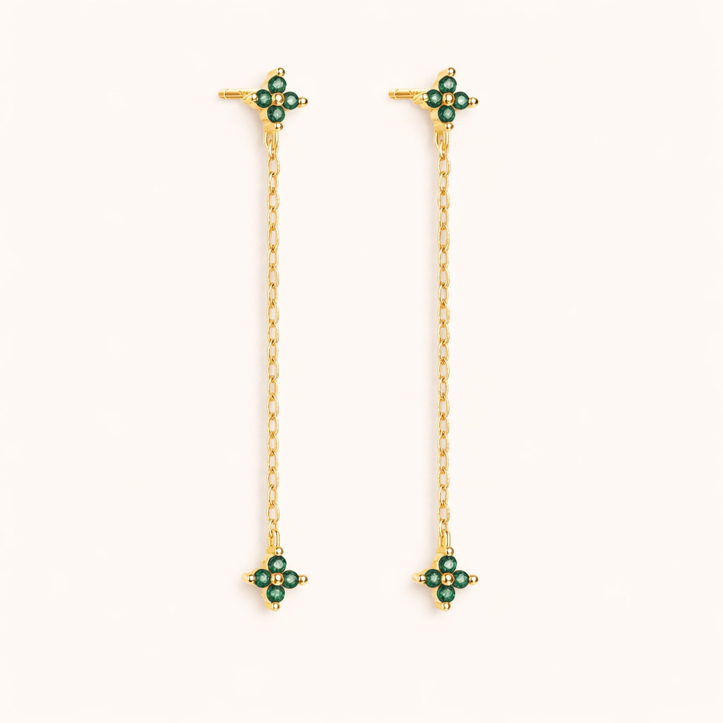 Zabbarra Earrings in gold with emerald-green crystals, a long chain drop connecting two matching clover-crystal stations.