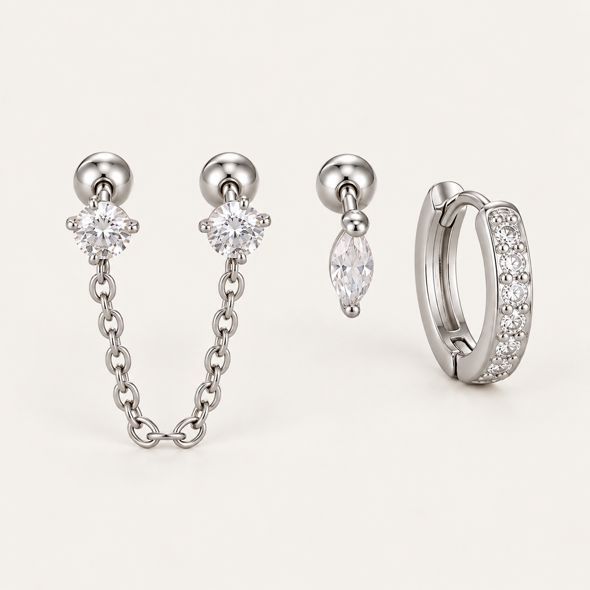 The Folie à Trois Zélie SET in silver: a chain-linked double stud, a marquise drop stud and a pavé huggie hoop.
