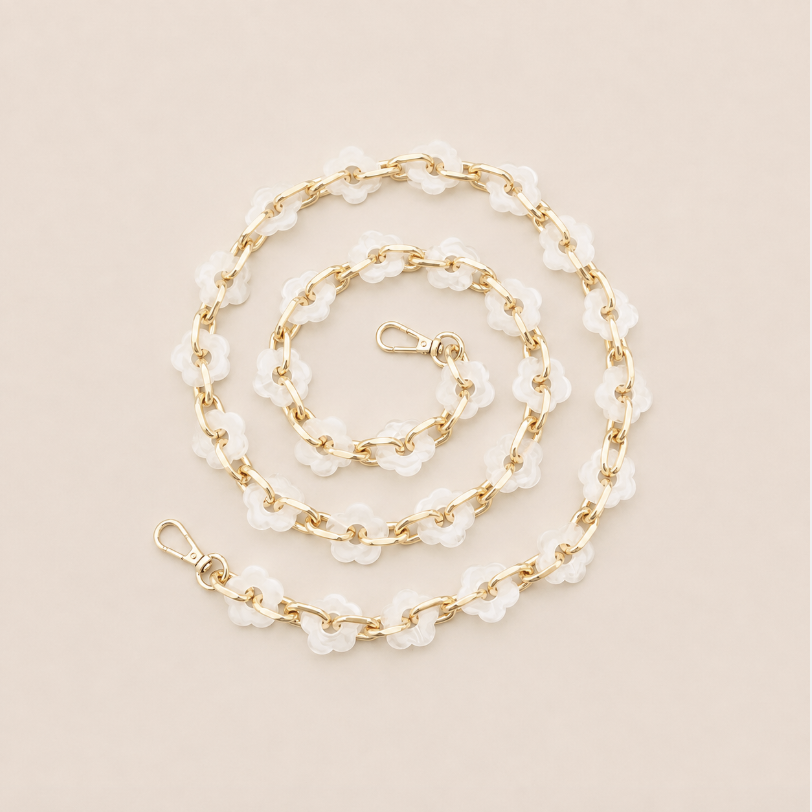 Coiled flower-link phone chain in frosted white acrylic with gold chain links on cream — Folie à Trois Zinnia wholesale phone chain