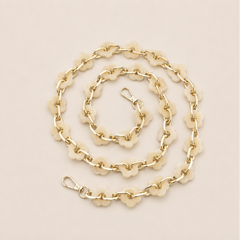 Coiled flower-link phone chain in ivory acrylic with gold chain links on a cream background — Folie à Trois Zinnia wholesale phone chain