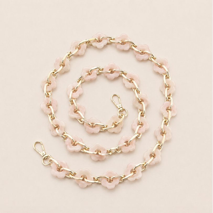 Coiled flower-link phone chain in blush pink acrylic with gold chain links on a cream background — Folie à Trois Zinnia long phone chain