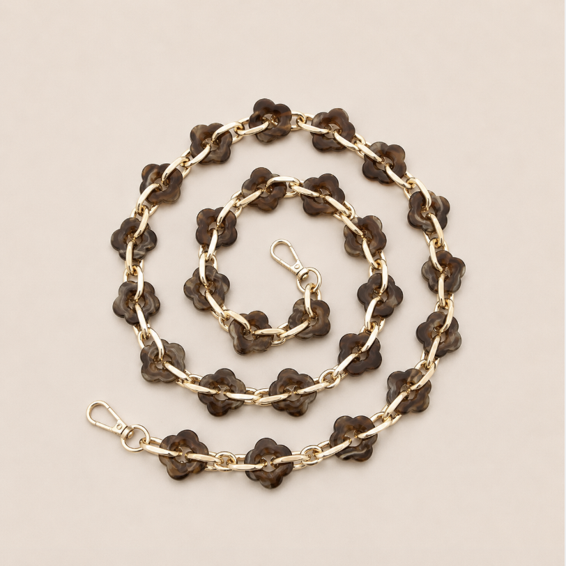 Coiled flower-link phone chain in deep brown tortoiseshell acrylic with gold chain links on cream — Folie à Trois Zinnia long phone chain