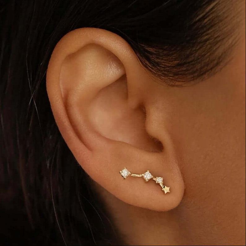 Worn at the lobe, Zodiac Stud Earrings form a starry gold constellation dotted with sparkling clear stones.