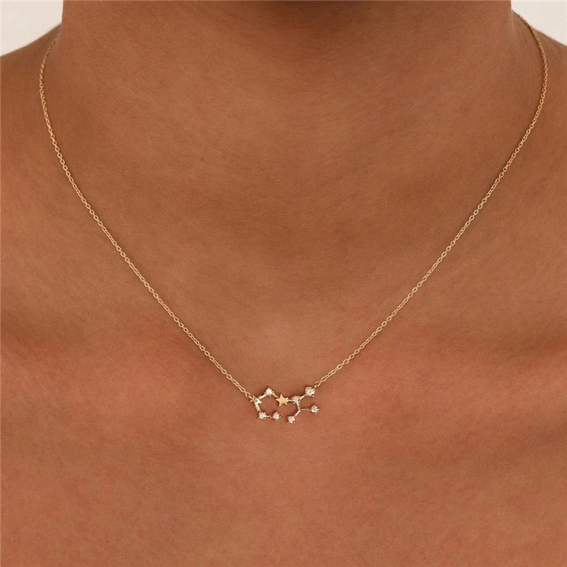 Close-up of a neckline wearing a fine gold Zodiac necklace with a crystal constellation pendant, Sagittarius Zodiac BUNDLE.