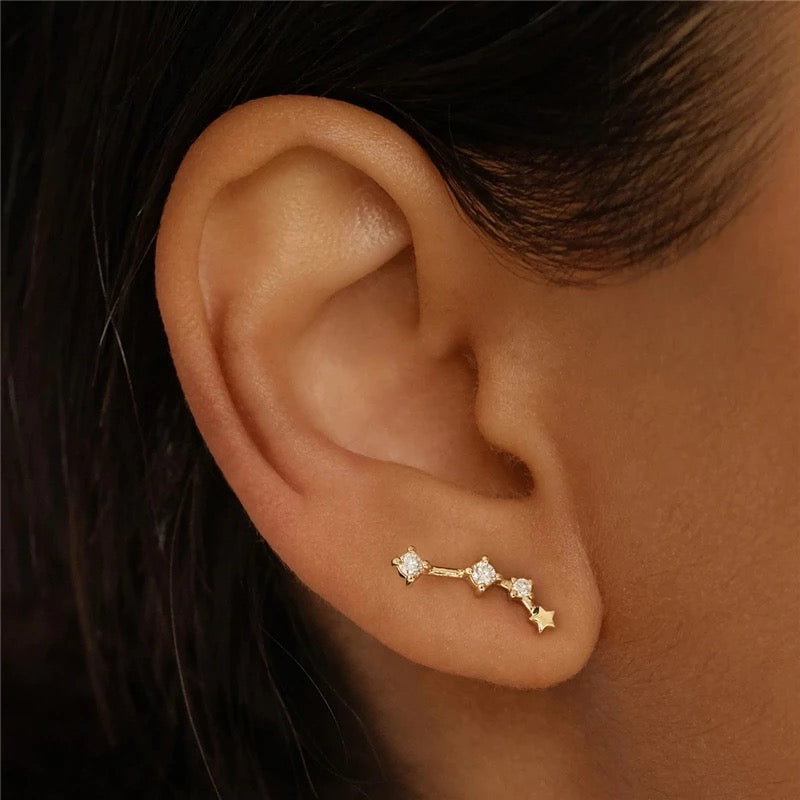 Ear wearing a gold Zodiac stud, a crystal-set constellation climbing the lobe, from the Aries Zodiac Stud and Necklace BUNDLE.